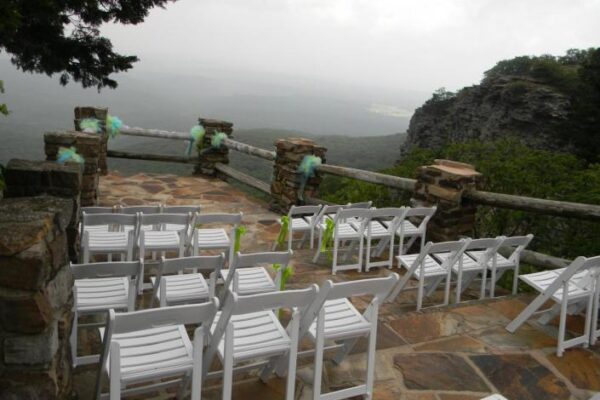 high rise view wedding ceremony with open scenery of rocks and trees with with chairs on brick floor