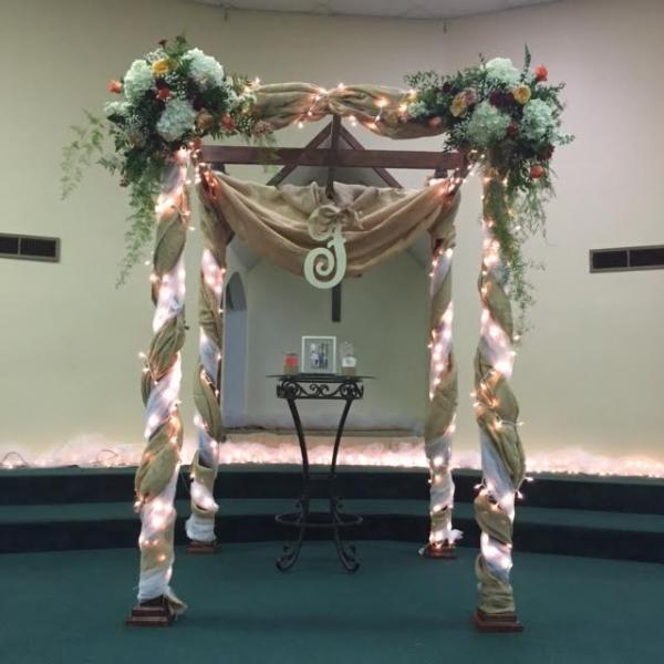 Lit up wedding arch with flowers on top
