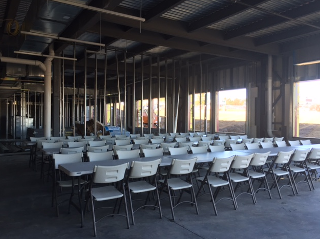 white tables and chairs set up in empty building