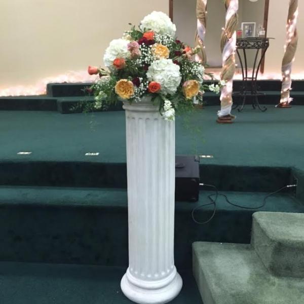 white tall podium with flowers on top