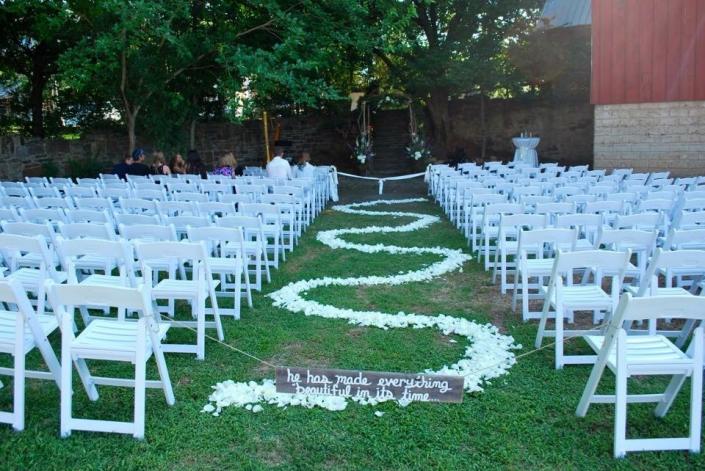 white chairs set up for ceremony in grass