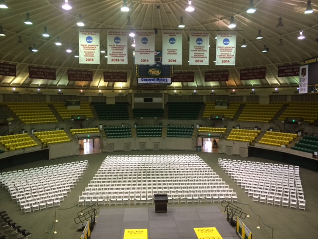 large amount of white chairs set up in event center